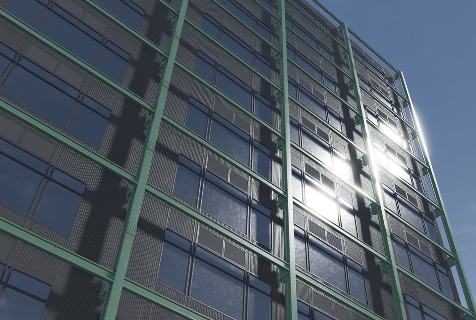 Glass building façade with greenish glazing, metal framing and reflected sunlight
